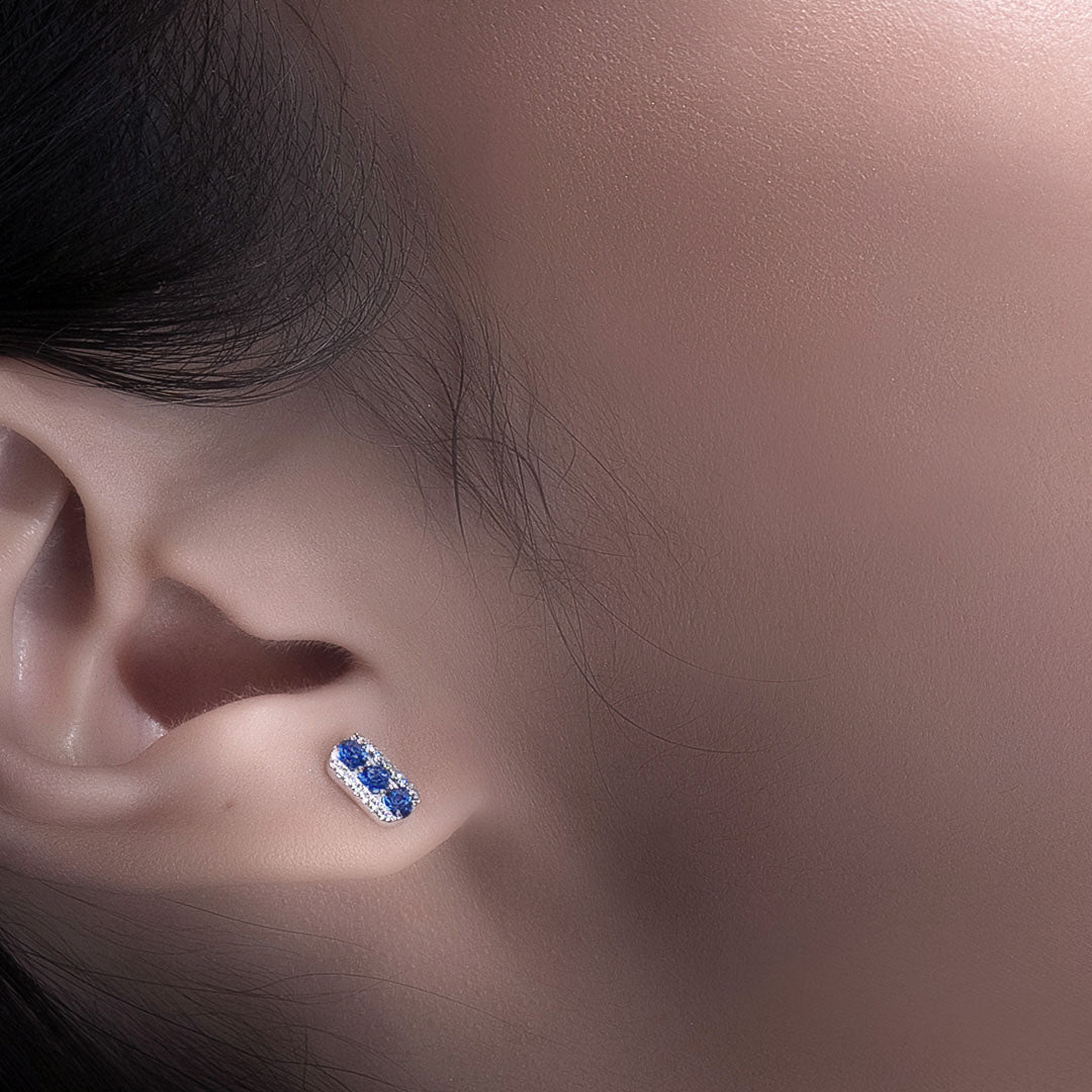 Lady wearing a Adamar Jewels CREENCIA Besito Earrings in 18K white gold set with sapphire and diamonds