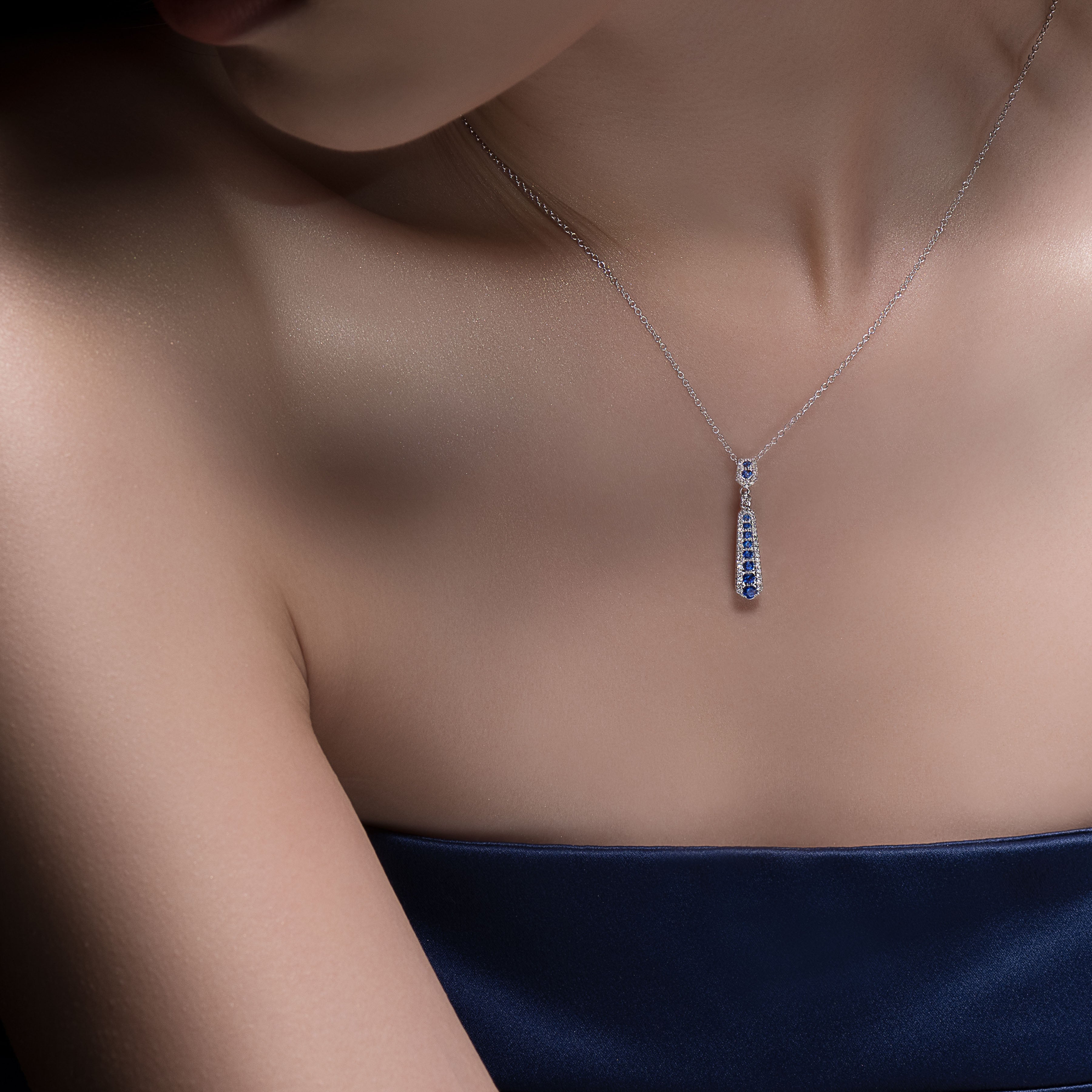 Lady wearing a Adamar Jewels CREENCIA Dulce Necklace in 18K white gold set with sapphire and diamonds