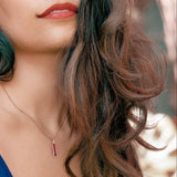 Lady wearing a Adamar Jewels CREENCIA Besito Necklace in 18K rose gold set with ruby and diamonds